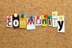 the word community written in cut out letters on a cork notice board