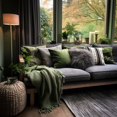 a living room filled with lots of furniture and pillows on top of a wooden floor