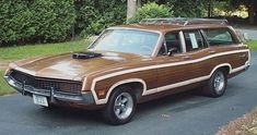 an old station wagon is parked on the side of the road in front of some trees