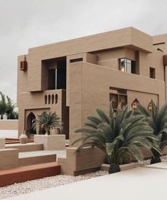 a large building with palm trees in front of it and stairs leading up to the entrance