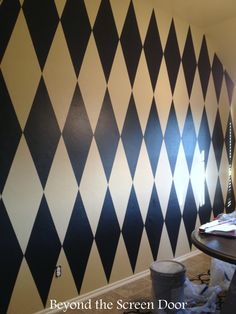 a room with black and white checkerboard wallpaper on the walls in it