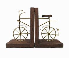 two metal figurines that look like bicycles on wooden bases, one with wheels and the other without spokes