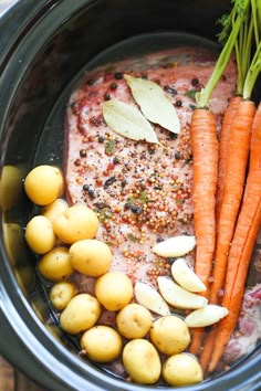 carrots, potatoes and meat in a crock pot with seasoning on top