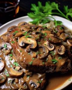 a white plate topped with meat covered in mushroom gravy