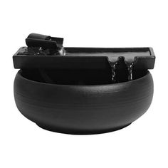 a black bowl with water pouring out of it