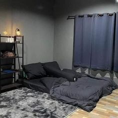 a bed sitting on top of a wooden floor next to a book shelf filled with books