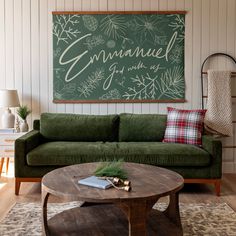 a living room with a green couch and coffee table in front of a chalkboard