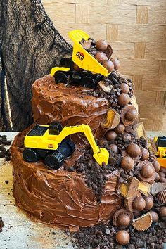 a cake with chocolate frosting and construction trucks on top