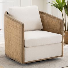 a white chair sitting on top of a rug next to a potted plant