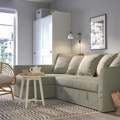 a living room with a couch, chair and coffee table in front of a window