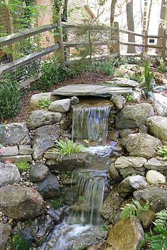 a small waterfall in the middle of a garden