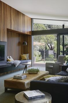 a living room filled with furniture and a flat screen tv on top of a wooden wall