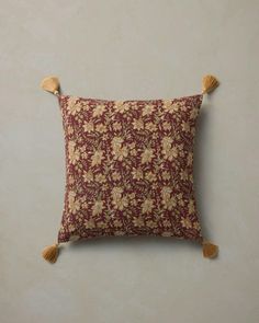 a decorative pillow with tassels hanging on the back of it's cushion