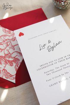 a red and white wedding card on top of a table