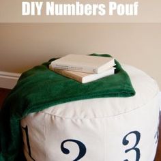 a white and green pouf with numbers on it sitting on a wooden floor next to a wall