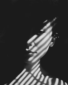 black and white photograph of a woman's face with the sun shining through her hair