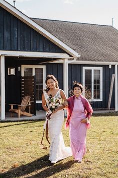 the bride and her mother are walking together in front of the barn at their wedding