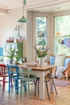 a dining room table with four chairs and a potted plant on top of it