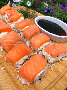 some salmon sushi is sitting on a cutting board