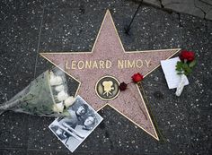 a star on the hollywood walk of fame with flowers and pictures laid out next to it