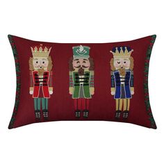 three nutcrackers on red velvet pillow