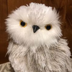 a white stuffed owl sitting on top of a table