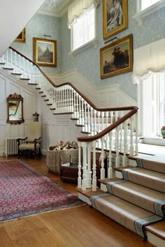 there is a staircase in the house with pictures on the wall and carpeted floor