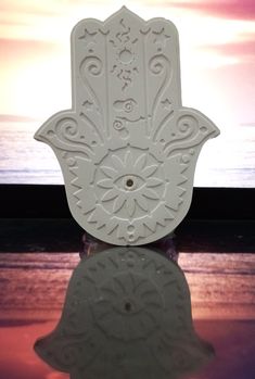 a small white hamsa sitting on top of a table