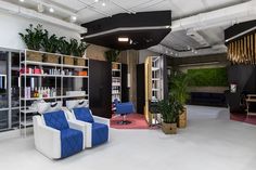 a living room filled with furniture and lots of shelves full of bookshelves next to a plant