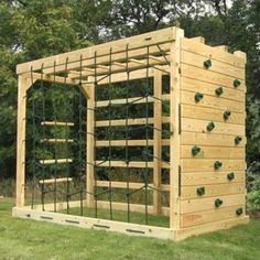 a wooden structure made out of pallets in the middle of some grass and trees