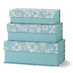 three blue boxes with white flowers on them are stacked up in the same row and one is empty