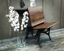 a wooden bench sitting next to a vase with flowers in it