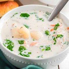 a close up of a bowl of soup with broccoli and scallops