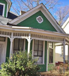 a green house with white trim on the front