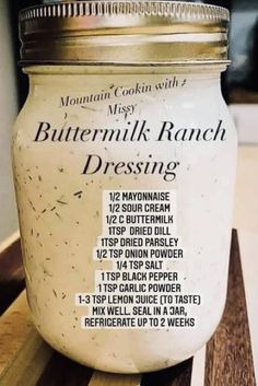 a jar of buttermilk ranch dressing sitting on a wooden counter top with instructions