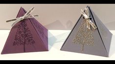 two folded origami trees with bows on them, one is purple and the other is silver