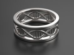 a silver ring with an intertwined design on the outside and inside, sitting on a black surface