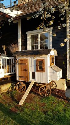 a small white house with wooden doors and windows