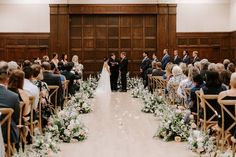 a bride and groom standing at the end of their wedding ceremony in front of an audience