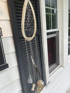 a wind chime hanging from the side of a house next to a window sill