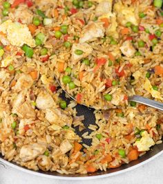 a pan filled with rice, peas and chicken