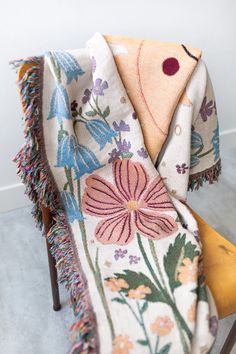 a chair with a blanket on top of it and a flower design on the back