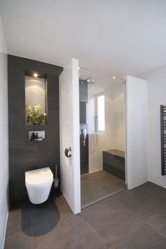 a bathroom with a white toilet sitting next to a walk in shower