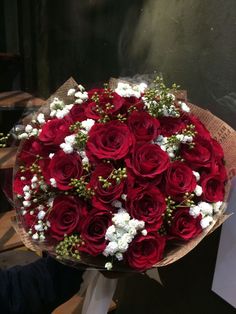 a bouquet of red roses and white baby's breath