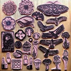 some pink and black paper cut outs on a table with flowers, birds, and other items