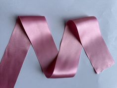 a pink satin ribbon on a white background