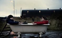 two people sitting in a bathtub on the ground