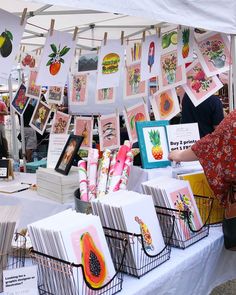 a table topped with cards and pictures under a white tent covered in paper art work