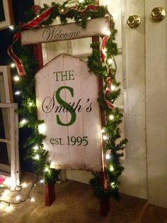 a sign that says the smith's is decorated with christmas lights and greenery