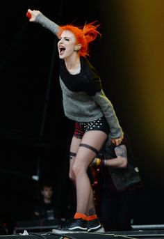 a woman with red hair is performing on stage